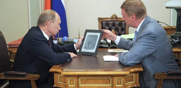 Vladimir Putin, primeiro-ministro da Rssia, segura um tablet de plstico produzido pela companhia russa Rosnano;  direita, Anatoly Chubais, diretor de tecnologia da empresa estatal