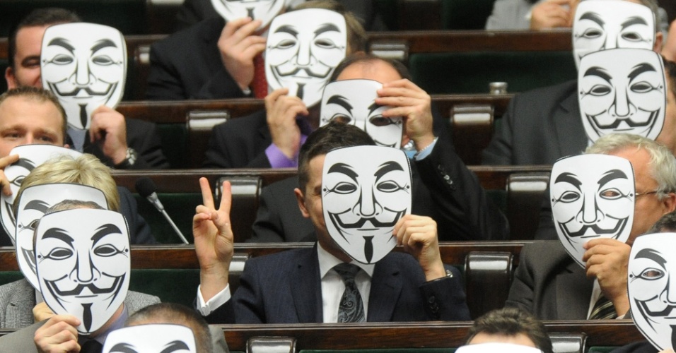 Deputados da esquerda polonesa usam máscaras símbolo do grupo hacker 'Anonymous' para protestar contra a adesão do país a padrões internacionais de direitos autorais (ACTA, na sigla em inglês)